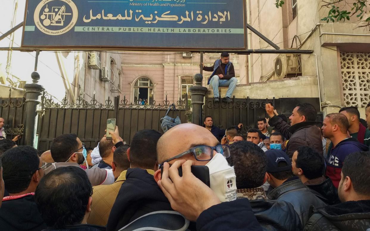 Egyptians gather in front of the Central Public Health Laboratories in downtown Cairo as they wait to get tested for COVID-19 coronavirus disease - AFP