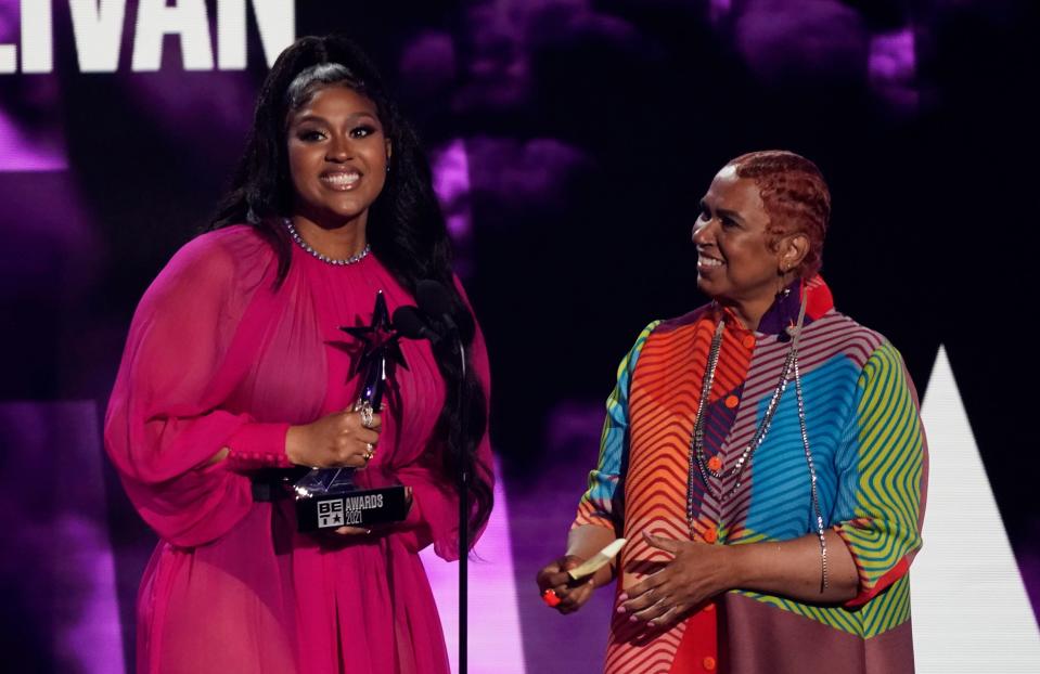 Jazmine Sullivan accepts the album of the year award for "Heaux Tales" as her mother Pam Sullivan looks on.