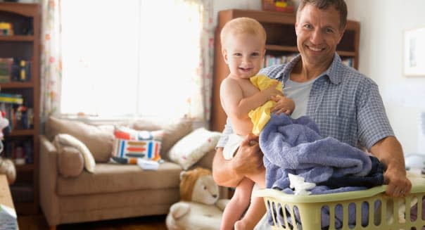 Caucasian father carrying son and laundry