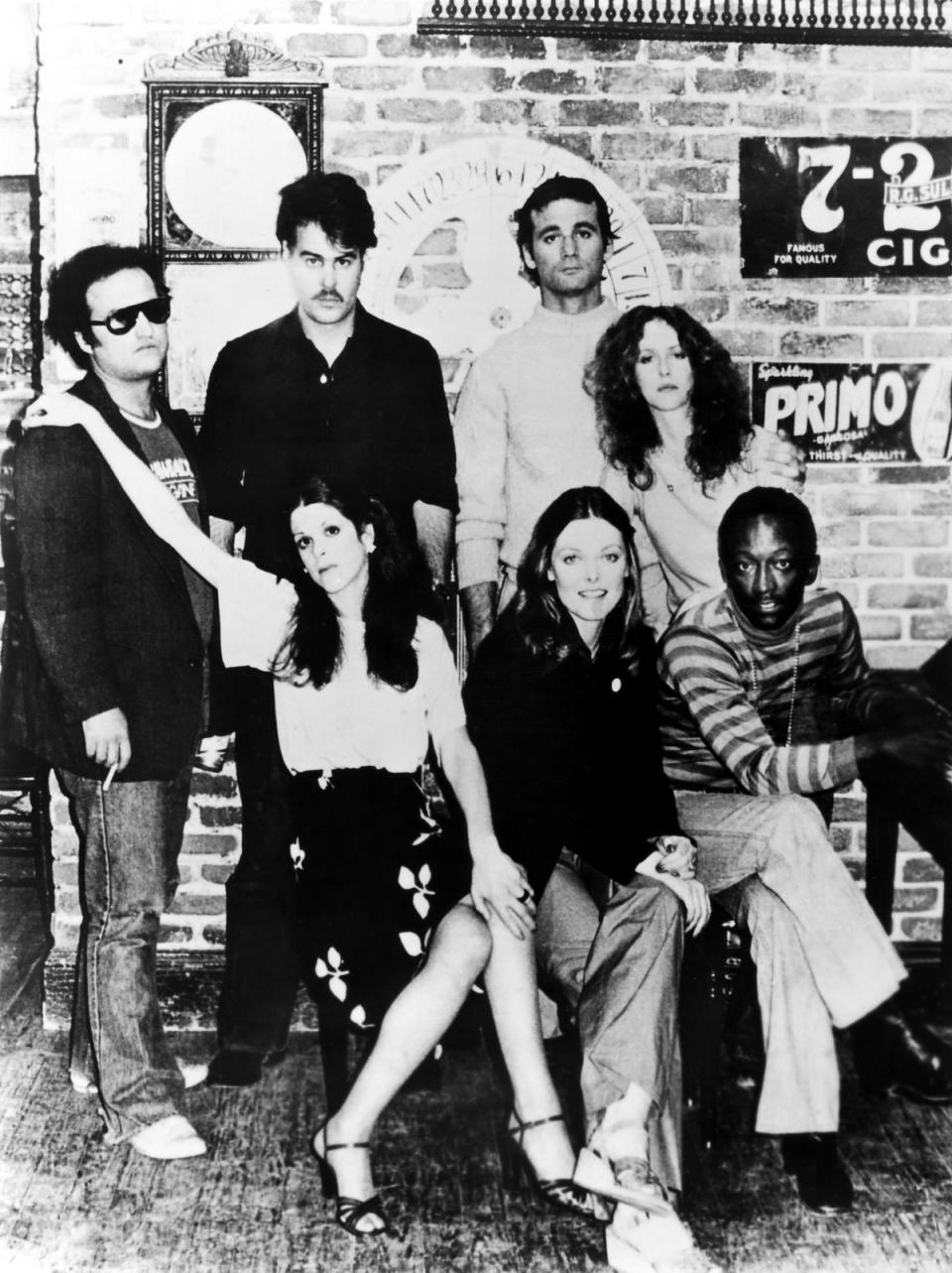 Saturday Night Live, 1977. Left To Right: (Standing) John Belushi, Dan Aykroyd, Bill Murray, Laraine Newman; (Seated) Gilda Radner, Jane Curtin, Garrett Morris. (Granger/Shutterstock)
