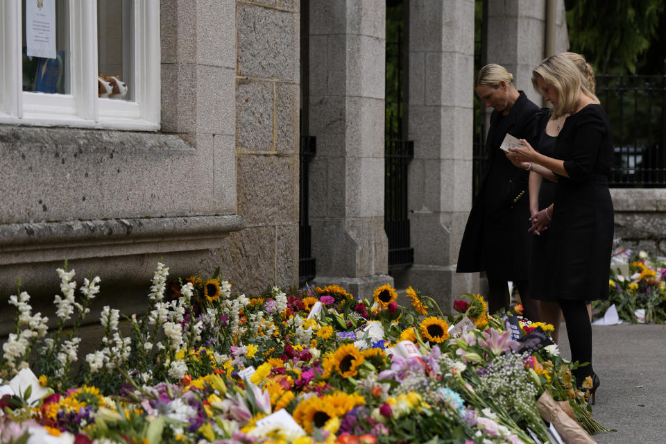 Sophie Countess of Wessex looks at a card from a floral tribute to Queen Elizabeth II outside the gates of Balmoral Castle in Aberdeenshire, Scotland Saturday, Sept. 10, 2022. Queen Elizabeth II, Britain's longest-reigning monarch and a rock of stability across much of a turbulent century, died Thursday after 70 years on the throne. She was 96. (AP Photo/Alastair Grant)