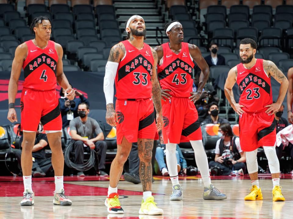 Scottie Barnes (left), Gary Trent Jr. (center-left), Pascal Siakam (center-right), and Fred VanVleet (right) stand on the court and look on during a Raptors game in 2022.
