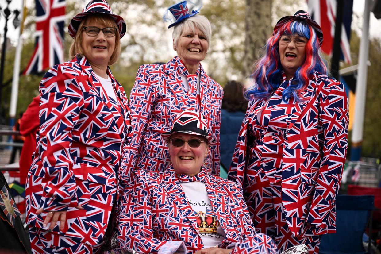 Royal fans dressed with different Union Jack-coloured items pose for pictures along the procession route, on The Mall, near to Buckingham Palace in central London, on May 5, 2023, ahead of the coronation weekend. - The country prepares for the coronation of Britain's King Charles III and his wife Britain's Camilla, Queen Consort on May 6, 2023. (Photo by Marco BERTORELLO / AFP) (Photo by MARCO BERTORELLO/AFP via Getty Images)