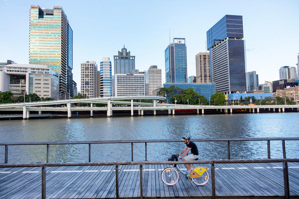 A man rides bicycle on the boardwalk on South Bank in Brisbane.