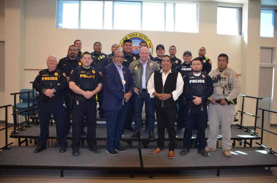 Sen. Mark Kelly poses with Tohono O'odham Nation Chairman Ned Norris, Pascua Yaqui Tribal Chairman Peter Yucupicio and members of local tribal law enforcement on Oct. 25, 2022 at the San Xavier District near Tucson.