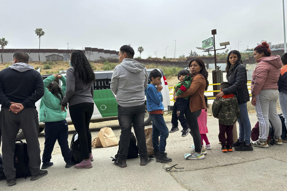 Migrants seeking asylum wait to be processed after crossing the border Wednesday, June 5, 2024, in San Diego, Calif. President Joe Biden has unveiled plans to enact immediate significant restrictions on migrants seeking asylum at the U.S.-Mexico border as the White House tries to neutralize immigration as a political liability ahead of the November elections. (AP Photo/Eugene Garcia)