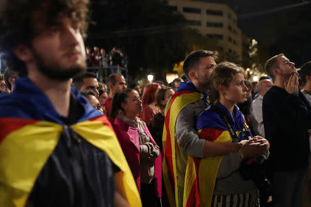 People react as they listen to Catalan president Carles Puigdemont during a gathering at Plaza Catalunya after voting ended for the banned independence referendum, in Barcelona, Spain October 1, 2017. REUTERS/Susana Vera