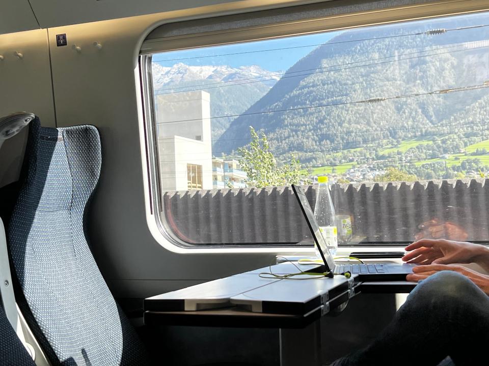 someone working on a computer while sitting on a train