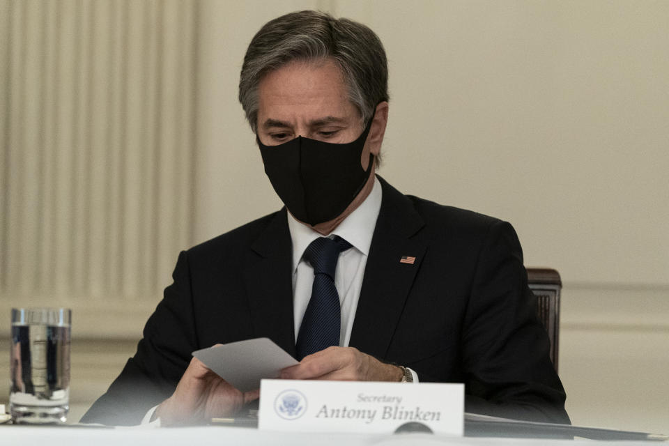 Secretary of State Antony Blinken looks at note from President Joe Biden, during a virtual meeting with Indian Prime Minister Narendra Modi, Australian Prime Minister Scott Morrison and Japanese Prime Minister Yoshihide Suga, from the State Dining Room of the White House, Friday, March 12, 2021, in Washington. (AP Photo/Alex Brandon)