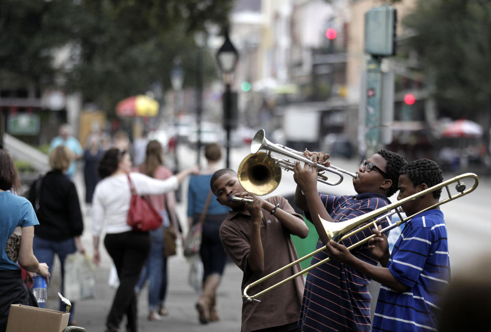 FILE - In this Nov. 11, 2011 photo, Willie Andrews, Revert Andrews, 15, center, and Revon Andrews, 13, right, of the New Life Brass Band, perform in the French Quarter section of New Orleans. Mayor LaToya Cantrell says the city of Mardi Gras fame receives barely more than 1 in 10 of each dollar collected from the taxes and fees visitors pay. (AP Photo/Gerald Herbert, File)