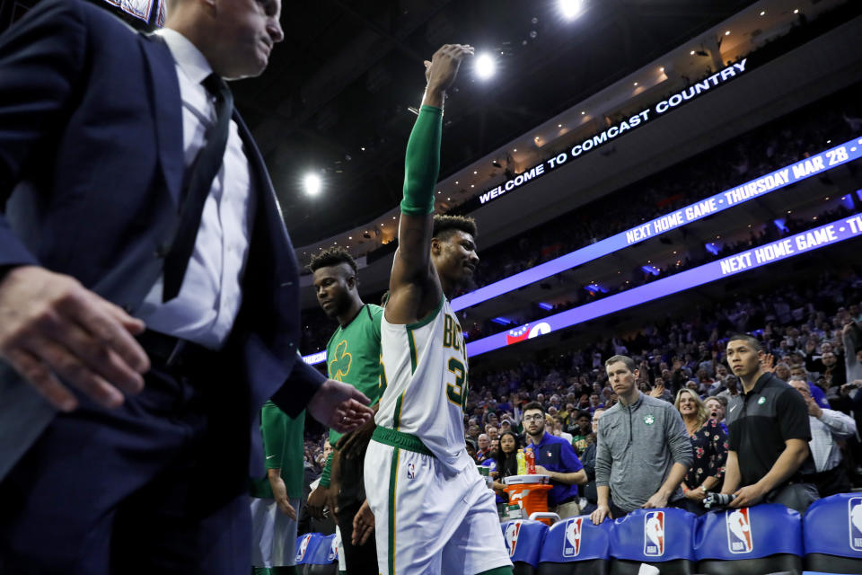 Boston Celtics' Marcus Smart gestures to the crowd as he is escorted off the court after committing a flagrant foul against Philadelphia 76ers' Joel Embiid during the second half of an NBA basketball game Wednesday, March 20, 2019, in Philadelphia. Philadelphia won 118-115. (AP Photo/Matt Slocum)