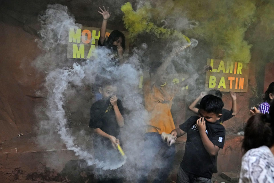 FILE - Boys light smoke bombs as they celebrate the eve of Eid al-Fitr, the holiday marking the end of the holy fasting month of Ramadan, in Jakarta, Indonesia, Sunday, May 1, 2022. (AP Photo/Dita Alangkara, File)