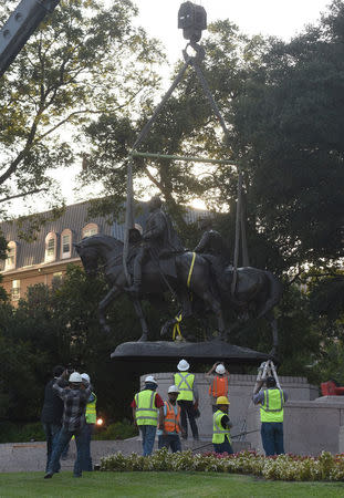 Workers remove the statue of Confederate general Robert E. Lee in Dallas, Texas, U.S., September 14, 2017. REUTERS/Rex Curry