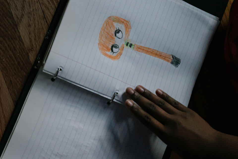 Image: Girl looking through a binder with drawings. (Caroline Gutman for NBC News)