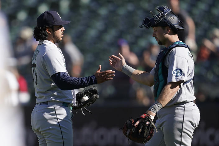 Seattle Mariners pitcher Andres Munoz, left, celebrates with catcher Cal Raleigh after the Mariners defeated the Oakland Athletics in a baseball game in Oakland, Calif., Thursday, Sept. 22, 2022. (AP Photo/Jeff Chiu)