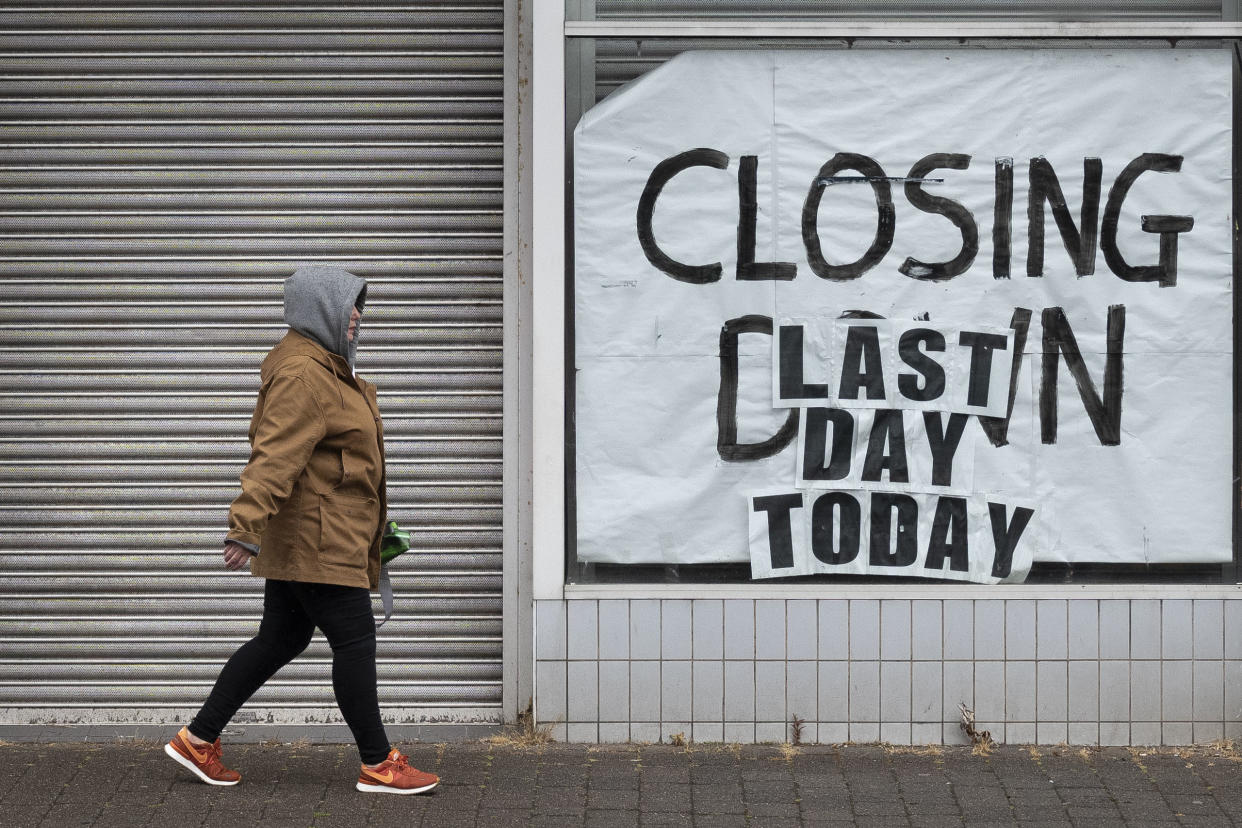 ABERDARE, UNITED KINGDOM - JUNE 10: A woman walks passed a closed-down shop on June 10, 2020 in Aberdare, United Kingdom. The Welsh government has further relaxed COVID-19 lockdown measures this week, allowing people from different households to meet up outside while maintaining social distancing. Schools have remained closed and those who have been advised to shield at home can go outside again but have been told to avoid shopping. (Photo by Matthew Horwood/Getty Images)