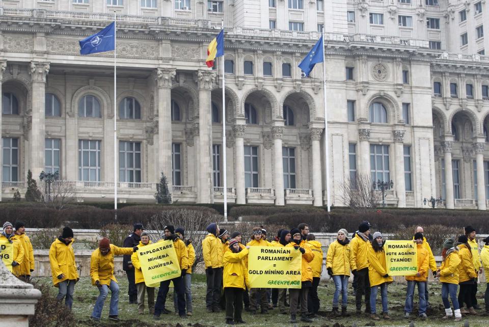 Greenpeace activists hold banners in the yard of Romania's Parliament in Bucharest