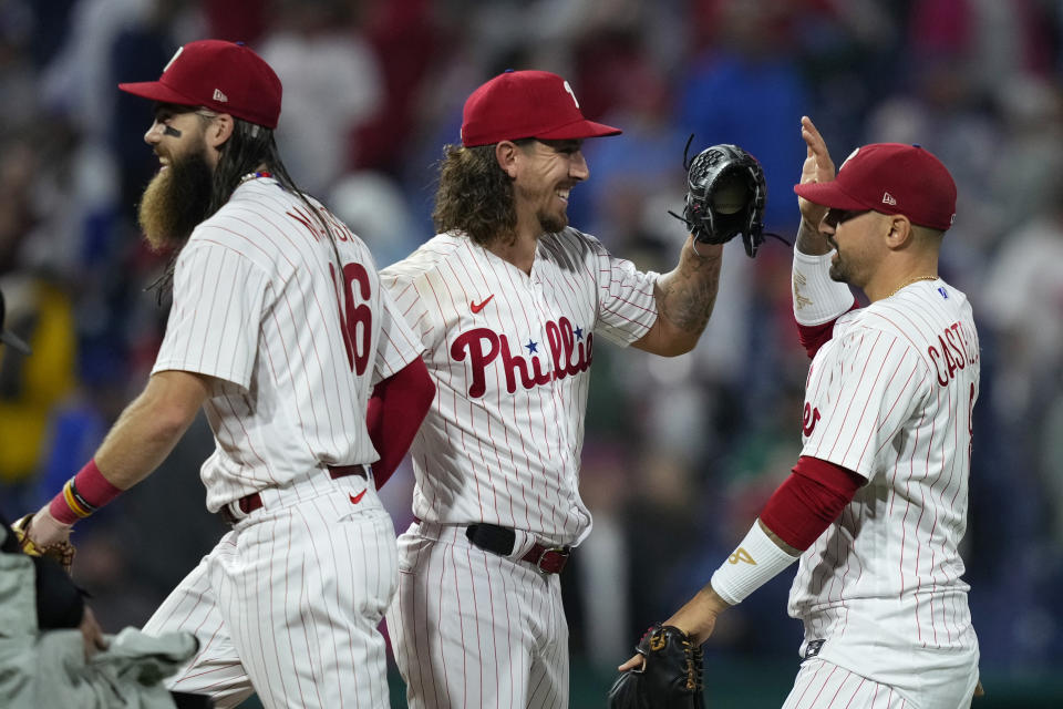 Philadelphia Phillies' Brandon Marsh, from left, Michael Lorenzen and Nick Castellanos celebrate after the Phillies won a baseball game against the New York Mets, Sunday, Sept. 24, 2023, in Philadelphia. (AP Photo/Matt Slocum)