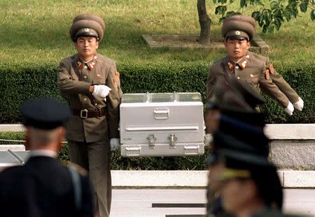 FILE PHOTO: North Korean soldiers carry a coffin believed to contain the remains of a U.S. soldier to the border with South Korea during repatriation ceremonies at the truce village of Panmunjom, South Korea, October 9, 1998. REUTERS/Yun Suk Bong/File Photo