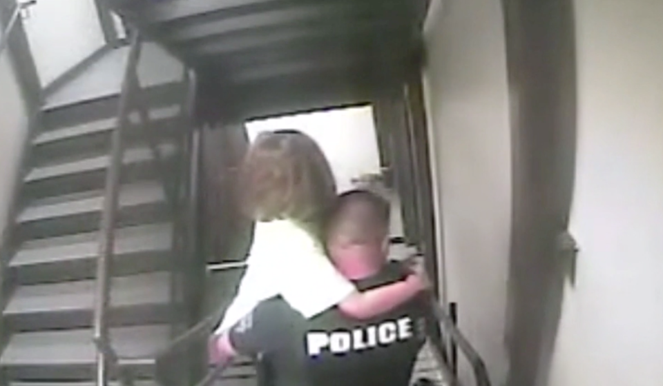 The young girl is carried out of the hotel by a police officer.