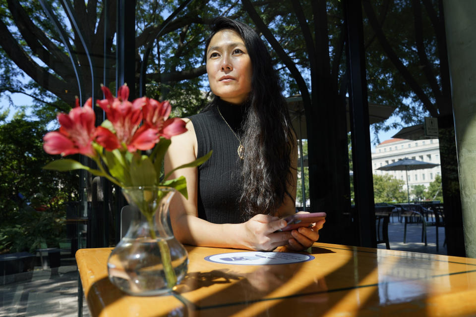 Sha Zhu, of Washington, who uses the app WeChat to keep in touch with family and friends in the U.S. and China, poses for a portrait, Tuesday Aug. 18, 2020, in Washington. For millions of people in the U.S. who use the Chinese app WeChat, it's a lifeline to friends, family, customers and business contacts in China. That lifeline is now under attack by an executive order from President Donald Trump that could ban the app in the U.S. as early as mid-September, potentially severing vital relationships. (AP Photo/Jacquelyn Martin)