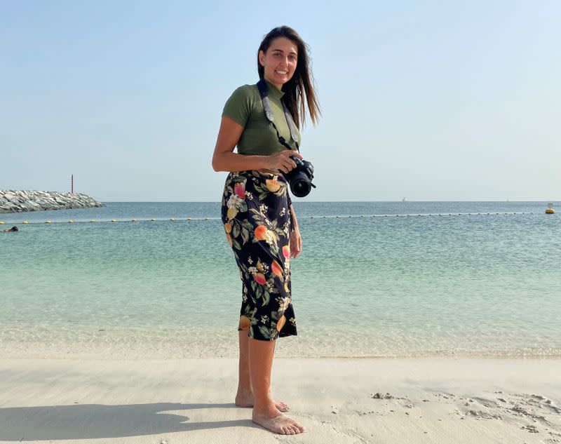 Paula Hainey, a photographer poses for a photo at the beach, as she gives free photo sessions for families who lost their jobs and will be leaving Dubai due to the coronavirus disease (COVID-19) outbreak, in Dubai