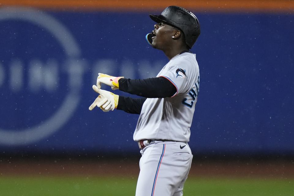 Miami Marlins' Jazz Chisholm Jr. gestures towards teammates after hitting an RBI double during the ninth inning of a baseball game against the New York Mets as rain falls Thursday, Sept. 28, 2023, in New York. (AP Photo/Frank Franklin II)
