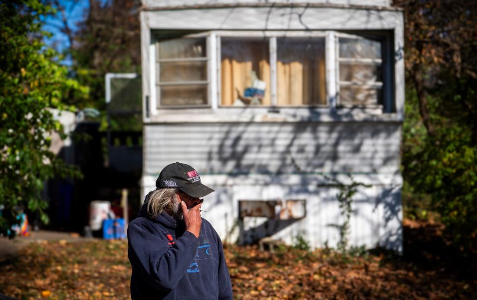 Larry Clay smokes a cigarette outside his trailer at Arlington Valley Mobile Home Park on the day of his eviction Thursday, Nov. 2, 2023.