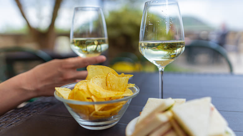 Two wine glasses and bowl of chips