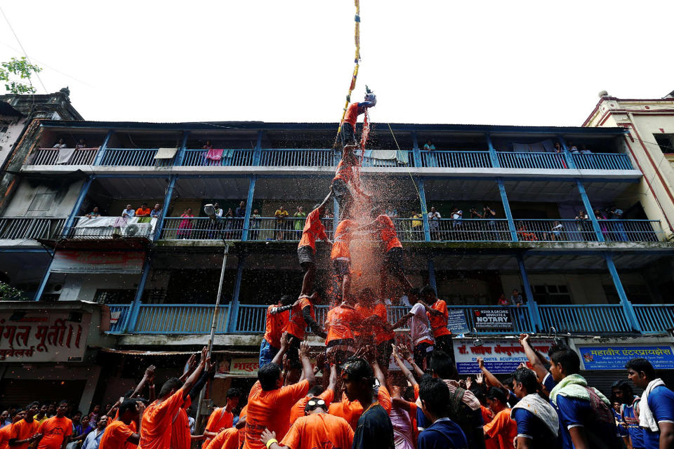 <p>A devotee breaks a clay pot containing curd as others form a human pyramid during celebrations to mark the Hindu festival of Janmashtami in Mumbai, India Aug. 25, 2016. (Photo: Danish Siddiqui/Reuters) </p>