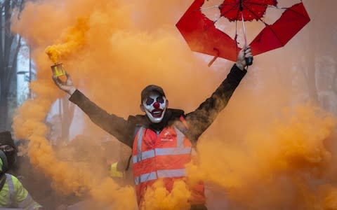 A masked protester holds a smoke grenade as public and private workers demonstrate and shout slogans in Marseille on December 5, 2019  - Credit: &nbsp;Arnold Jerocki/Getty Images Europe