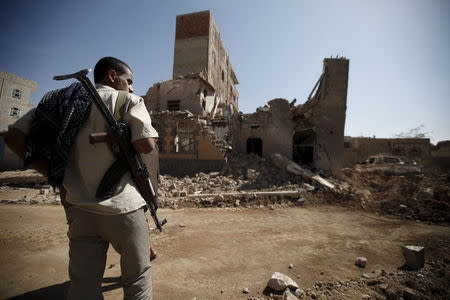 A Houthi militant stands past a destroyed house at the site of Saudi-led air strikes in Yemen's capital Sanaa October 28, 2015. REUTERS/Khaled Abdullah