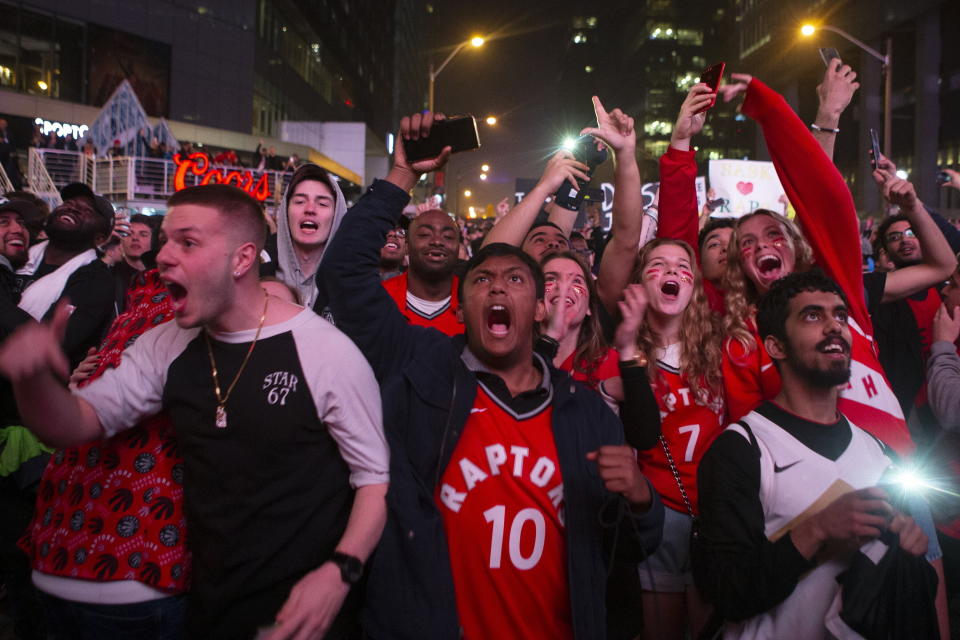 Toronto Raptors fans celebrate outside the arena in the closing seconds of the team's 100-94 win over the Milwaukee Bucks in Game 6 of the NBA basketball playoffs Eastern Conference finals Saturday, May 25, 2019, in Toronto. The Raptors advanced to the NBA Finals. (Chris Young/The Canadian Press via AP)