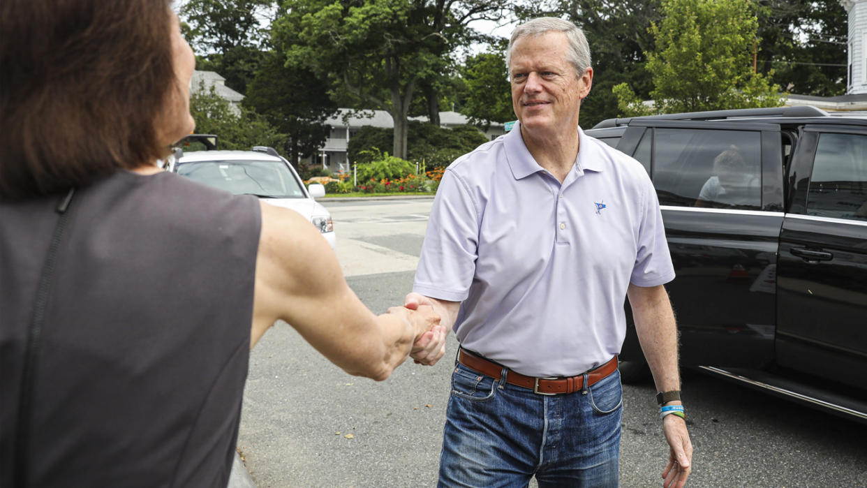 Gov. Charlie Baker shakes the hand of Holly Grant, CEO at American Red Cross of Massachusetts, while arriving with his wife, Lauren, to donate at a Red Cross blood drive at the Magnolia Library and Community Center in Gloucester on July 1, 2021. (Erin Clark/The Boston Globe via Getty Images)