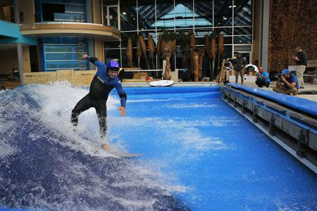 Todd Holland, former professional surfer on the world tour, tests the waves on a surfboard at the still under-construction Surf's Up indoor water and surf park in Nashua, New Hampshire November 15, 2013. REUTERS/Brian Snyder