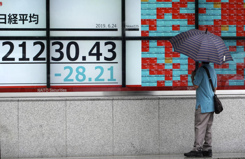 A man looks at an electronic stock board showing Japan's Nikkei 225 index at a securities firm in Tokyo Monday, June 24, 2019. Shares were wavering in Asia on Monday as investors watched for movement in the China-U.S. trade dispute ahead of a meeting between Presidents Donald Trump and Xi Jinping planned for later this week in Osaka, Japan, at the Group of 20 summit. (AP Photo/Eugene Hoshiko)