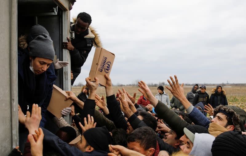 Members of United Nations High Commissioner for Refugees deliver food to migrants at Turkey's Pazarkule border crossing with Greece's Kastanies, in Edirne