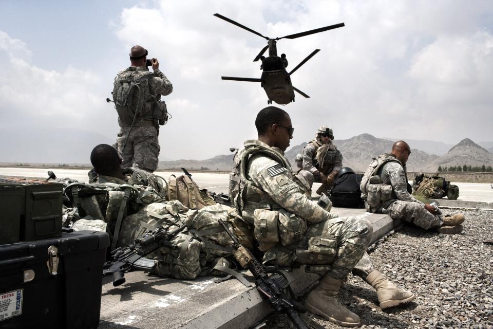 US Army soldiers from the Alpha Company 1/121 Infantry (L), 48th BCT and US Army Embedded Training Team and Human Terrain Team wait on a landing strip for an helicopter to fly to Spera District Center (DC) on August 18, 2009 in Camp Parsa, Nader Shah Kot, Khost Province, Afghanistan. (Marco Di Lauro/Getty Images)