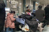 Relatives gather near the beds of sickened patients at the emergency department of the Langfang No. 4 People's Hospital in Bazhou city in northern China's Hebei province on Thursday, Dec. 22, 2022. As China grapples with its first-ever wave of COVID mass infections, emergency wards in the towns and cities to Beijing's southwest are overwhelmed. Intensive care units are turning away ambulances, residents are driving sick relatives from hospital to hospital, and patients are lying on floors for a lack of space. (AP Photo/Dake Kang)