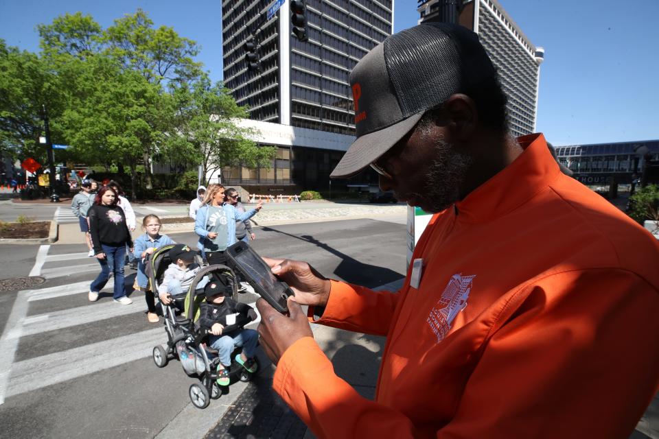 Ronnie O’Bannon, a safety ambassador, was helping a vistor find coffee downtown as they headed to Thunder Over Louisville at Waterfront Park. April 22, 2023.