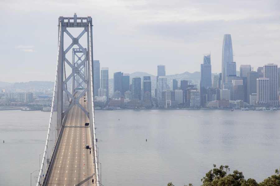 Police stand on empty westbound lanes while the bridge remained closed. (Photo by JASON HENRY/AFP via Getty Images)