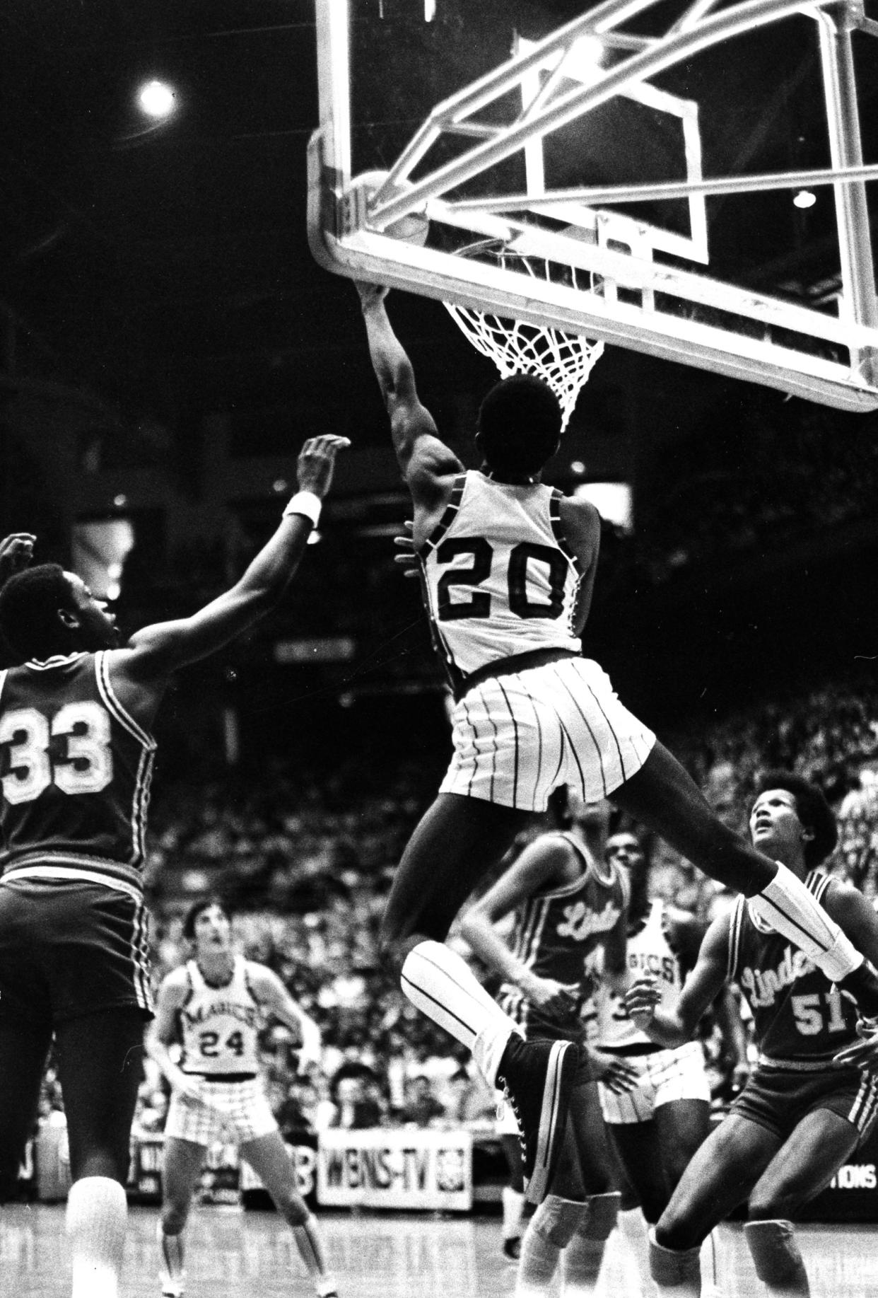 Former Barberton High School basketball star Carter Scott makes an acrobatic move around the basket in March 1977.