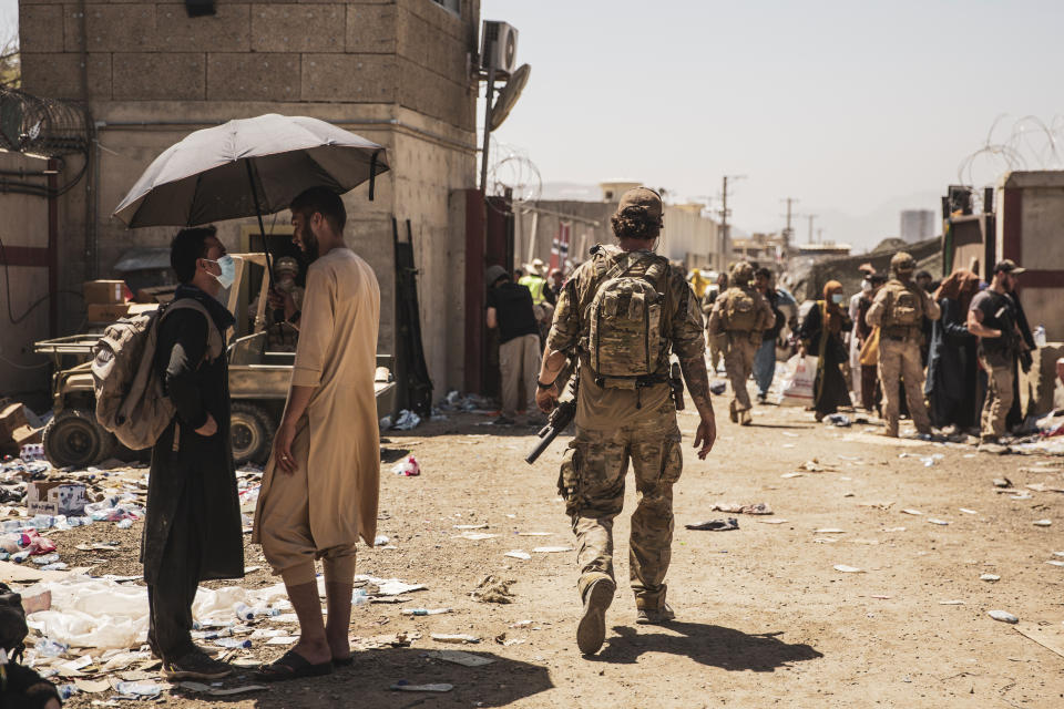 In this image provided by the U.S. Marine Corps, a Canadian coalition forces member walks through an evacuation control checkpoint during ongoing evacuations at Hamid Karzai International Airport, Kabul, Afghanistan, Tuesday, Aug. 24, 2021. (Staff Sgt. Victor Mancilla/U.S. Marine Corps via AP)