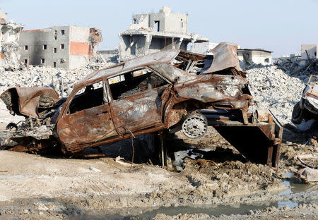 Remains of a car and buildings are seen following a security campaign against Shi'ite Muslim gunmen in the town of Awamiya, in the eastern part of Saudi Arabia August 9, 2017. REUTERS/Faisal Al Nasser