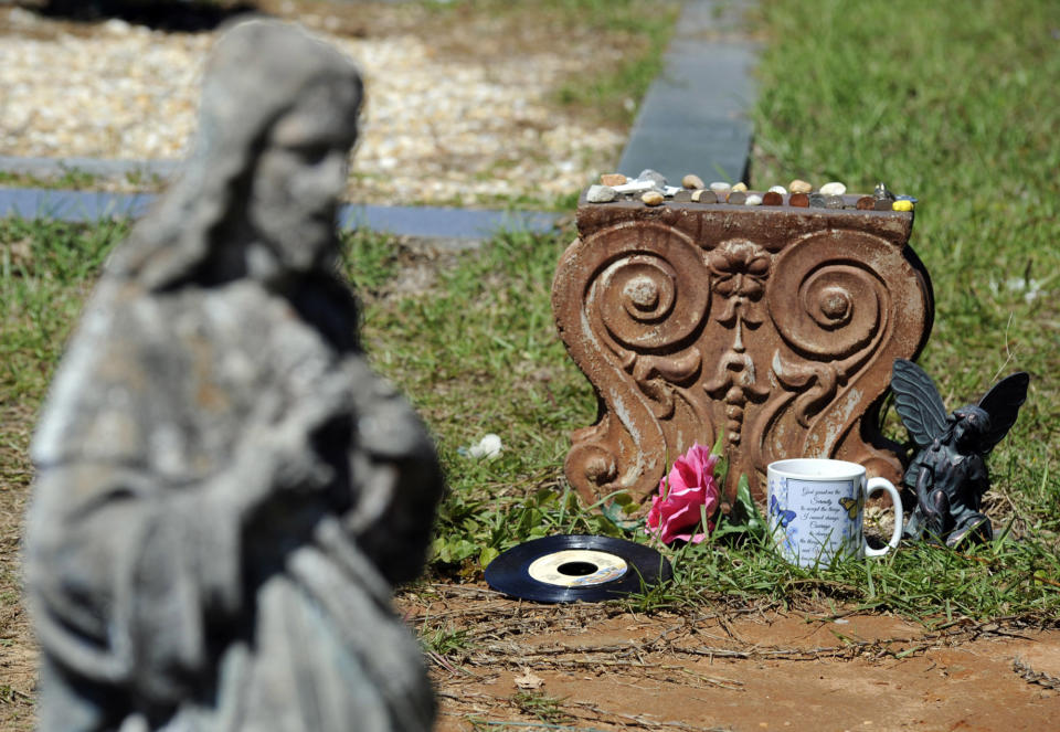 FILE - In this photo taken Wednesday, May 3, 2017, is a statue of Jesus near the grave of John B. McLemore, who is featured in the serialized podcast "S-Town," in Green Pond, Ala. A lawsuit against the makers of the hit podcast “S-Town” has been dismissed after a settlement with the late protagonist's estate. WIAT-TV reported Tuesday, May 19, 2020, that the suit filed by the estate of John B. McLemore was dismissed March 12. Details of what the settlement entailed were not disclosed. (AP Photo/Jay Reeves, File)