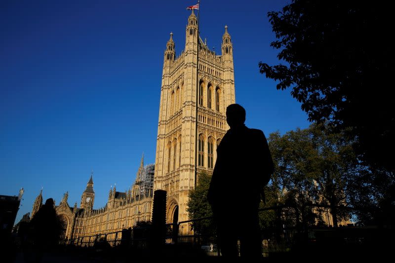 FILE PHOTO: People are silhouetted against the Houses of Parliament in central London