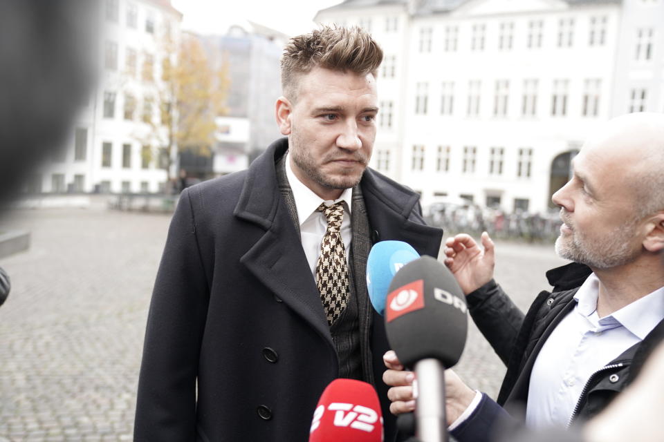 Nicklas Bendtner and lawyer Anders Nemeth talk to the media outside the Copenhagen City Council