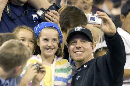 Toronto Blue Jays pitcher Roy Halladay takes a photo with unidentified fan in pre-game activities in Toronto, June 3, 2007. REUTERS/Fred Thornhill