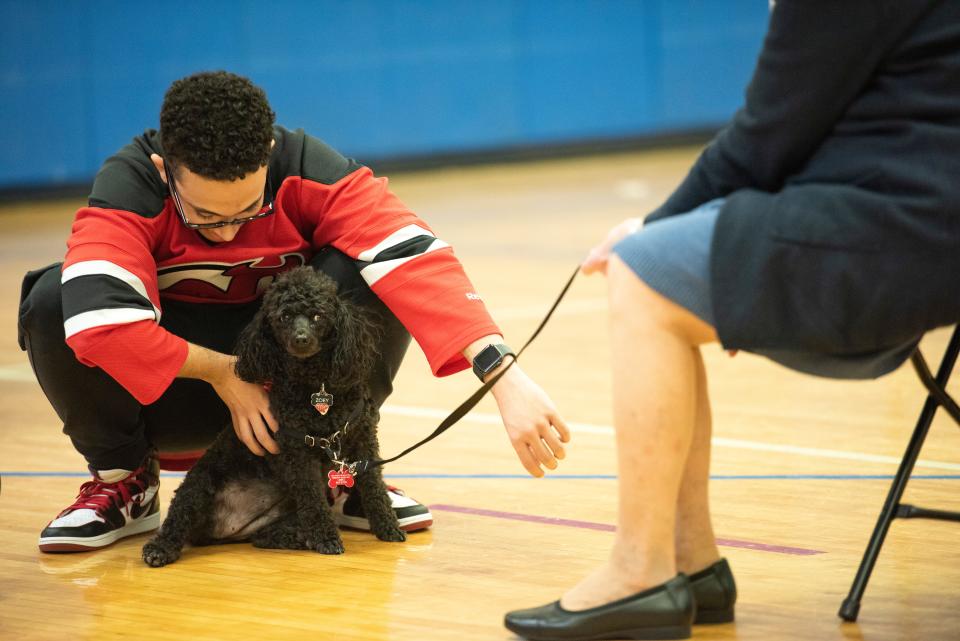 Student Gabriel Santana canoodles with Zoey, a therapy dog.