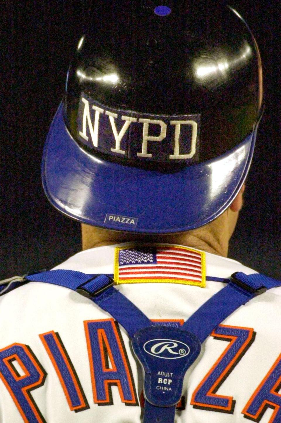 FILE - In this Sept. 21, 2001, file photo, New York Mets catcher Mike Piazza wears the NYPD logo on his helmet as he takes the field in the top of the fifth inning against the Atlanta Braves in New York. Sports teams will hold ceremonies Saturday, Sept.11, 2021, to mark the 20th anniversary of the Sept. 11 terrorist attacks. (AP Photo/Mark Lennihan, File)